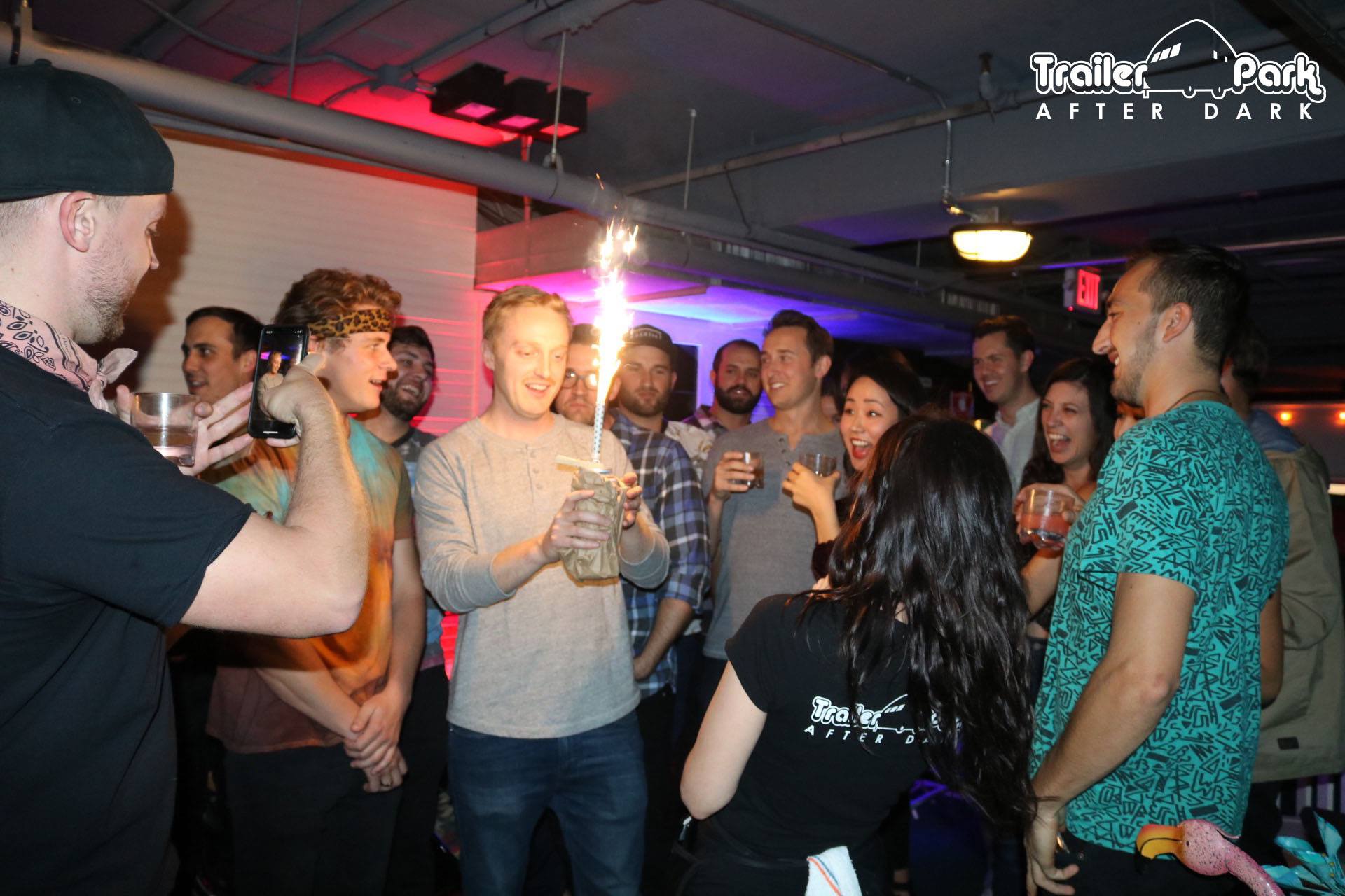 Guests cheering as sparklers light up a group celebration at Trailer Park After Dark in the Gaslamp Quarter